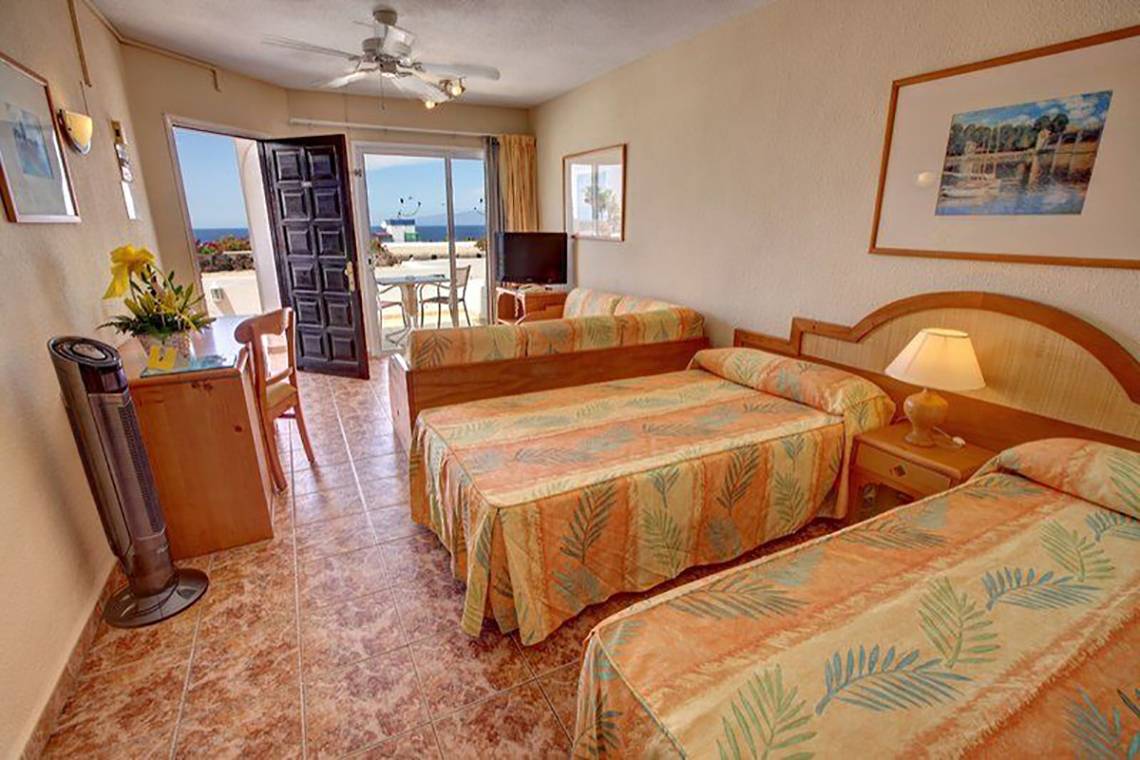 Schlafzimmer im Hovima Panorama Hotel mit zwei Betten, Aussicht auf das Meer und Balkon.