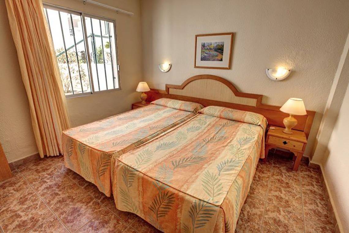 Doppelzimmer im Hovima Panorama Hotel mit zwei Betten, Nachttischen und Lampen