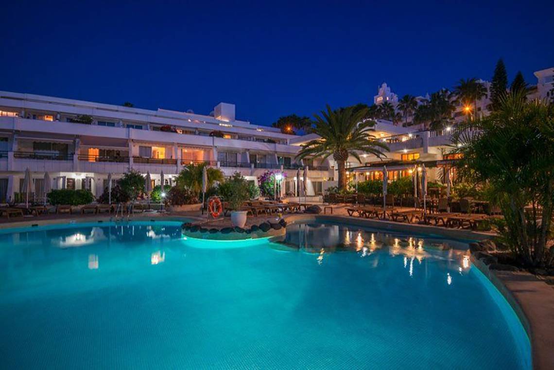 Der Pool des Hovima Panorama Hotels bei Nacht, beleuchtet und mit Loungebereich davor.