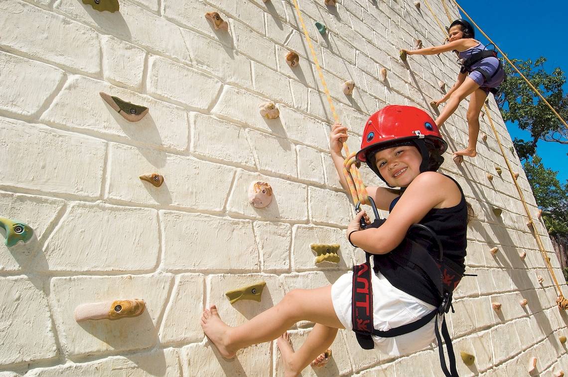 Zwei Kinder klettern an einer Wand im Dreams Tulum Resort & Spa.