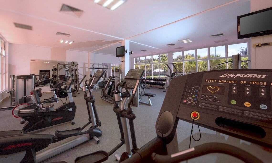 Fitnessstudio im Dreams Tulum Resort & Spa mit Laufband, Rudermaschine und Hantelbank