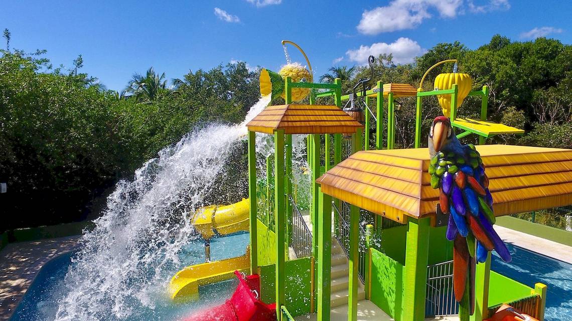 Wasserspielplatz im Dreams Tulum Resort & Spa mit Wasserrutschen und buntem Papagei