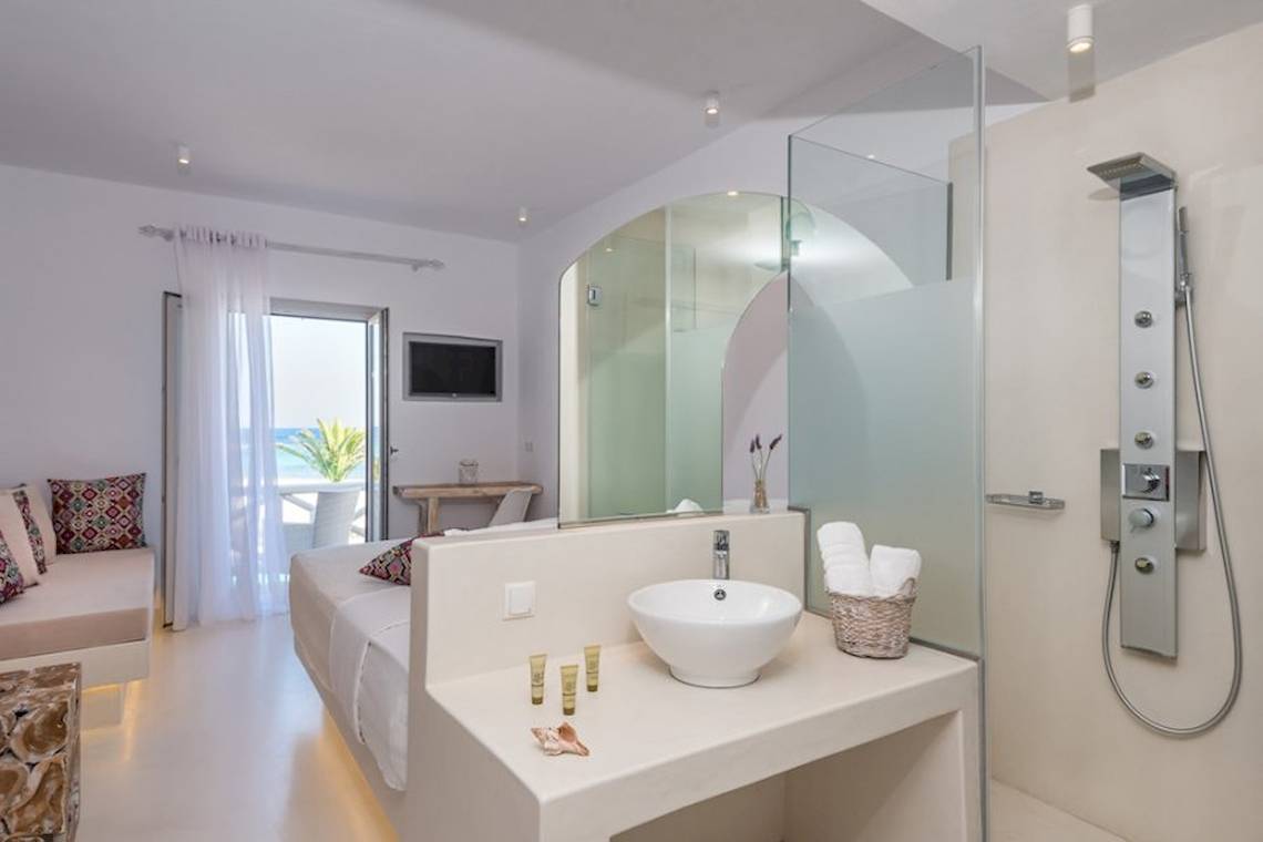 Badezimmer im Sunrise Mykonos Hotel mit modernem Design, Dusche und Badewanne.