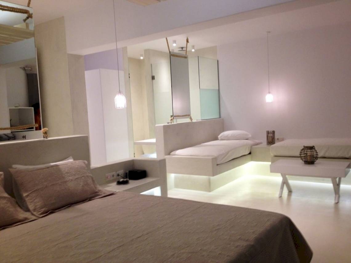 Schlafzimmer im Sunrise Mykonos Hotel mit weißen Möbeln und integrierten Beleuchtungselementen.