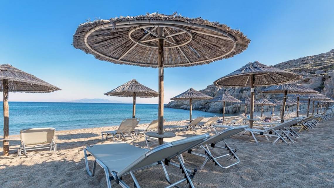 Strand mit Sonnenschirmen und Liegen am Sunrise Mykonos Hotel