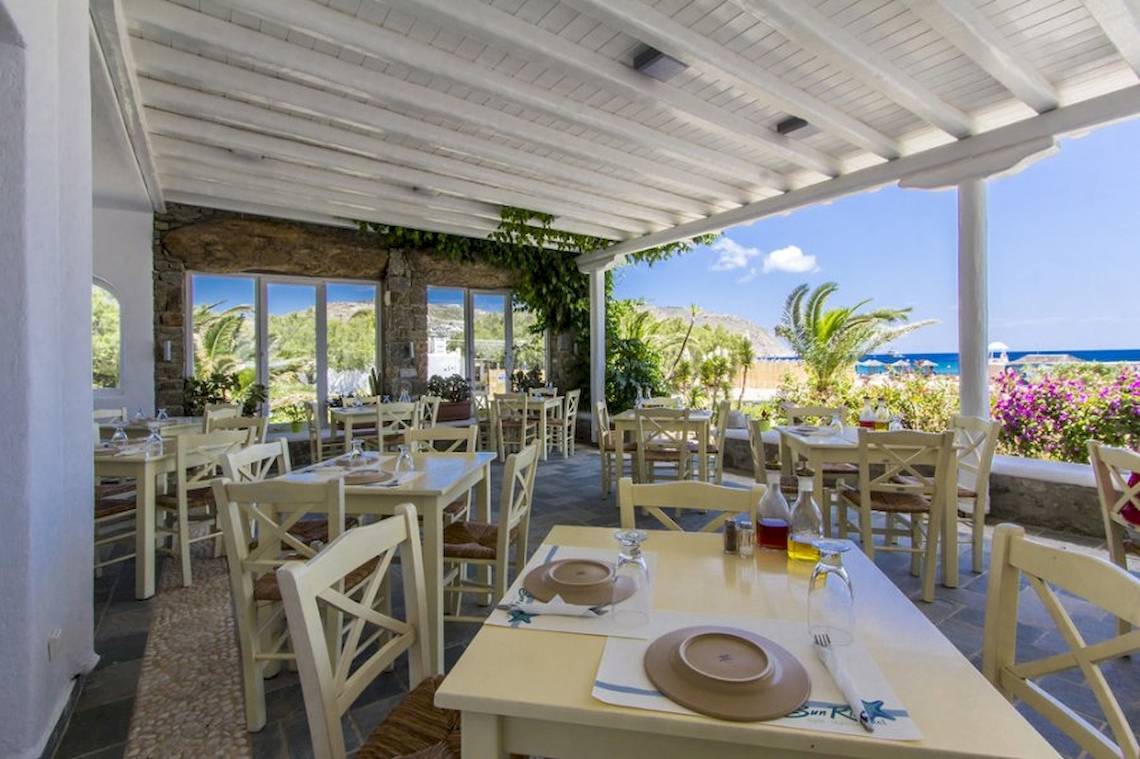 Terrasse des Sunrise Mykonos Hotels mit Blick auf das Meer und die Berge.
