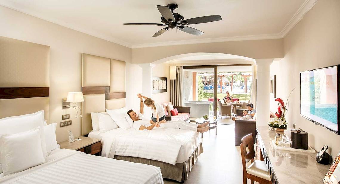 Suite im Barcelo Maya Grand Resort mit zwei Betten, Wohnzimmer und Terrasse.