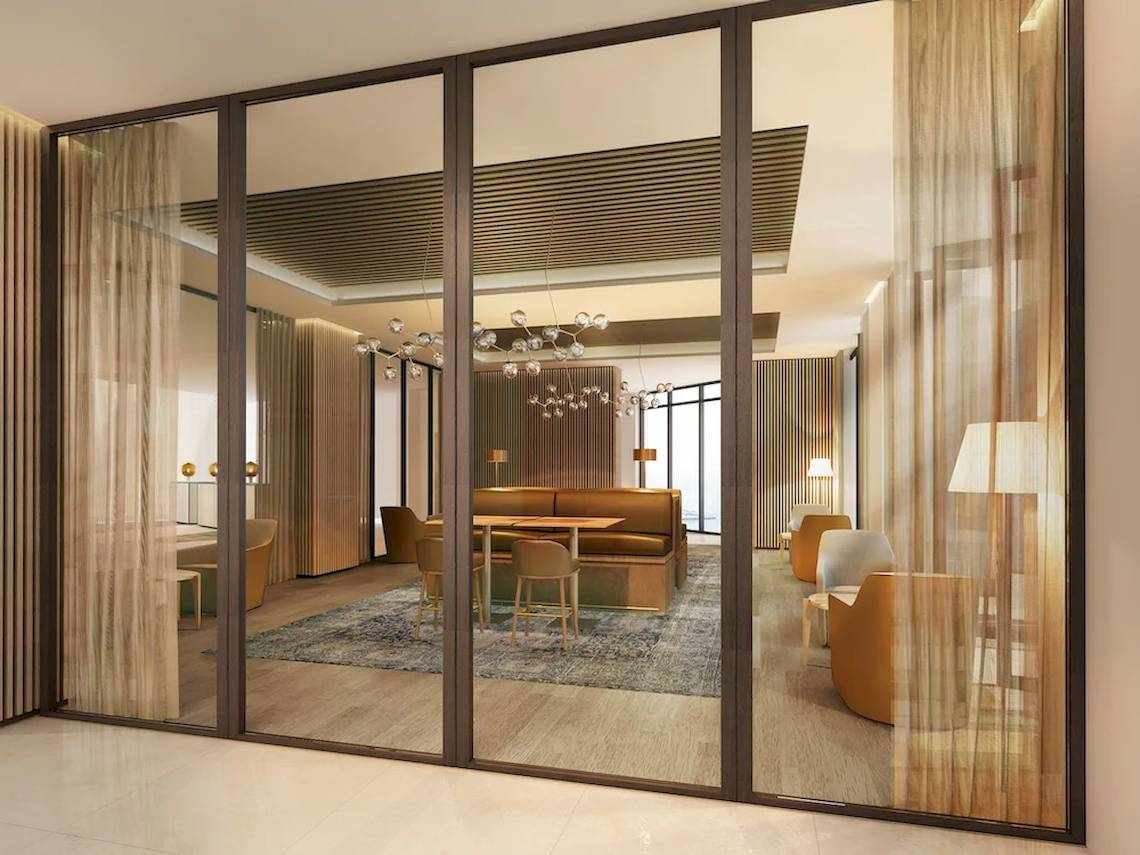 Inneneinrichtung des Mysk Al Mouj Hotels mit Glaswänden, Möbeln und Lampen.