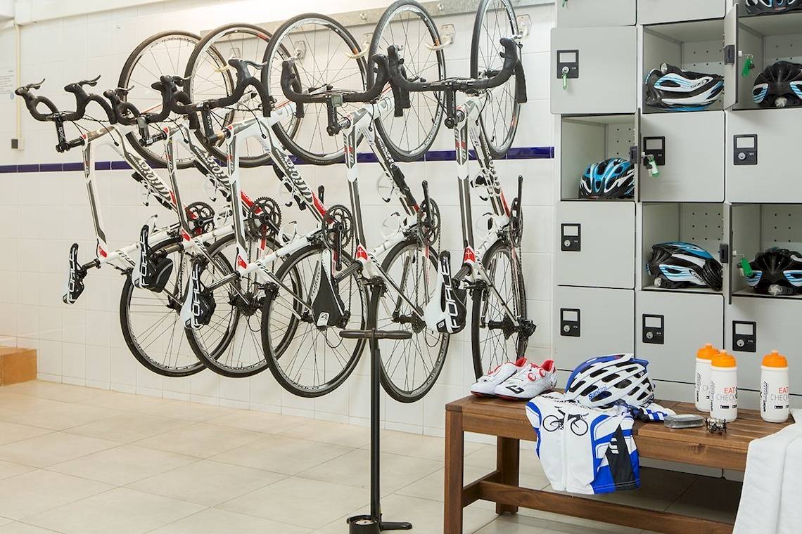 Ein Raum mit mehreren Fahrrädern an der Wand aufgehängt und Ausrüstung auf einem Tisch im Universal Hotel Neptuno.