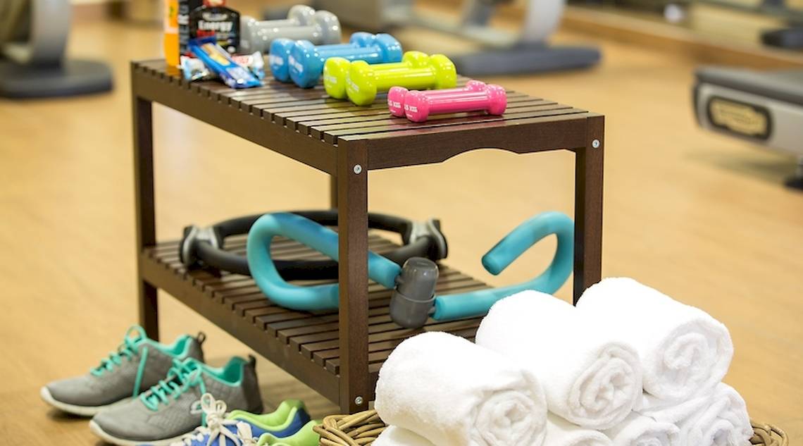Fitness-Zubehör im Universal Hotel Neptuno, einschließlich Hanteln, Fitnessbändern und Handtüchern.