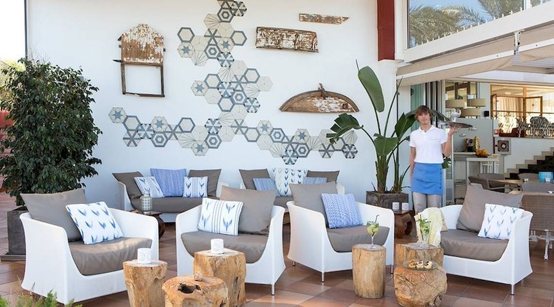 Empfangsbereich des Universal Hotel Neptuno mit modernen Möbeln und geometrischen Wanddekorationen.