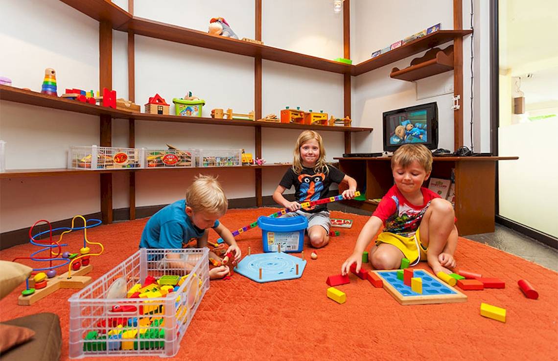 Kinder spielen im Spielzimmer des Dewa Phuket Resort mit Legos und anderen Spielzeugen.