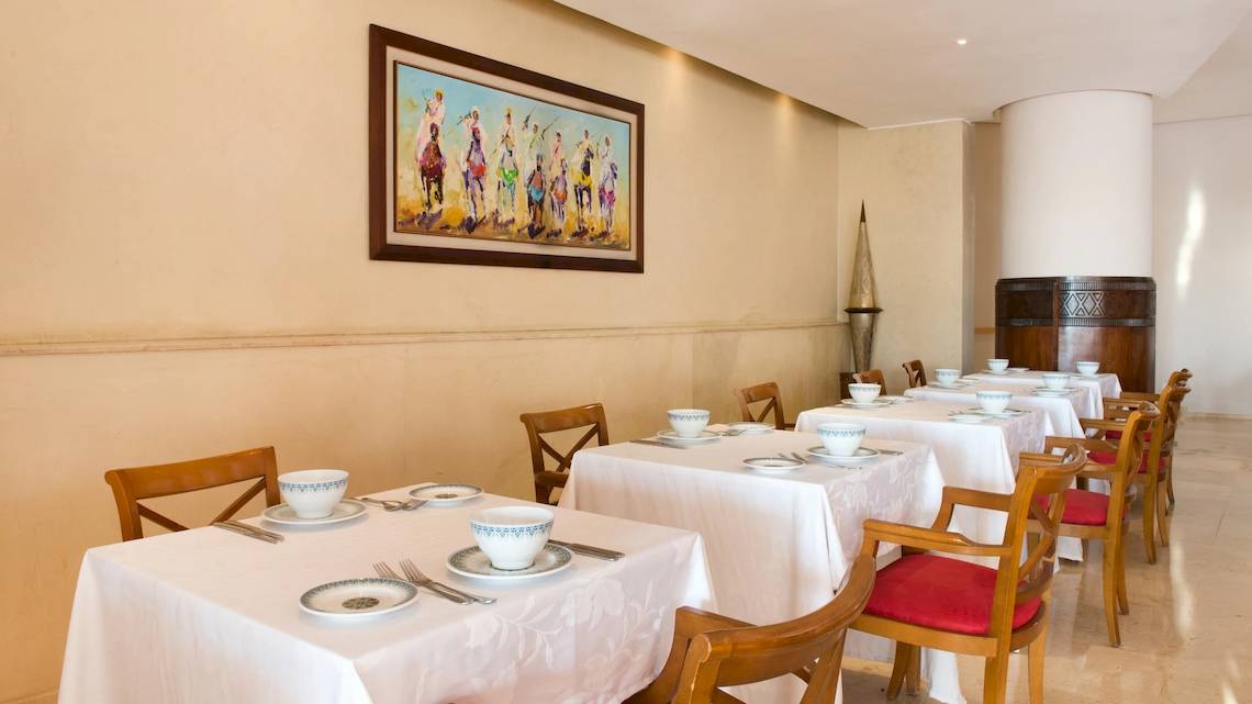 Ein langer Tisch im Speisesaal des Iberostar Founty Beach Hotels, elegant eingerichtet mit weißen Tischdecken und Geschirr.