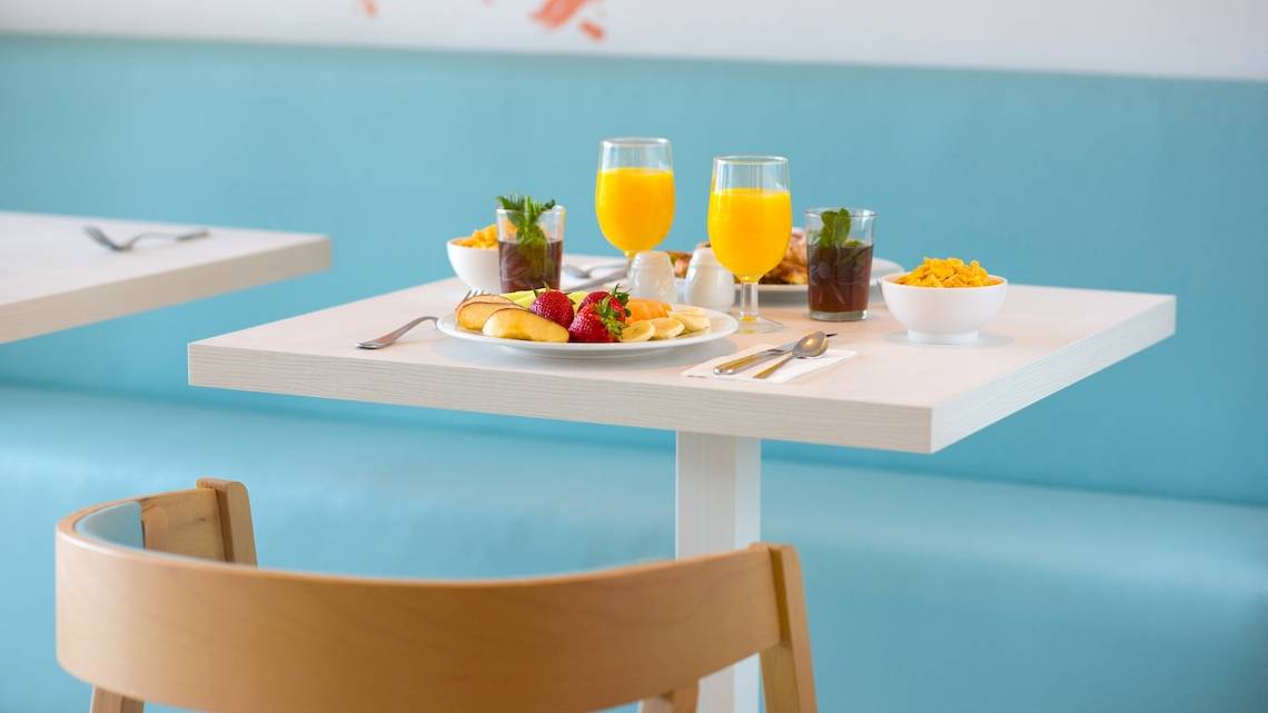 Frühstückstisch im Iberostar Founty Beach Hotel mit Früchten, Orangensaft und verschiedenen Getränken.