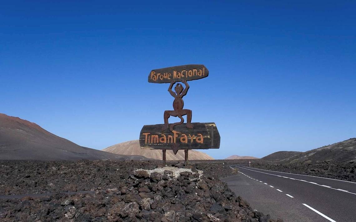 Schild des Nationalparks Timanfaya auf einem Felsen neben einer Straße