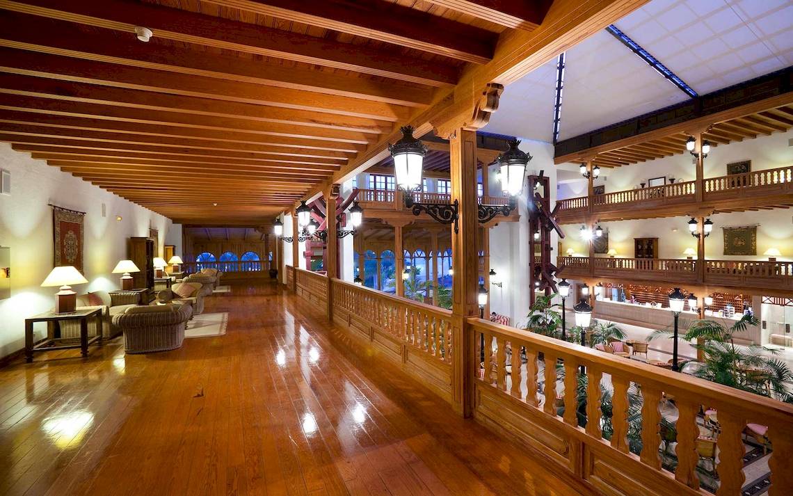 Innenbereich des Seaside Los Jameos Hotels mit Holzböden, Holzbalkendecken und viktorianischen Lampen.