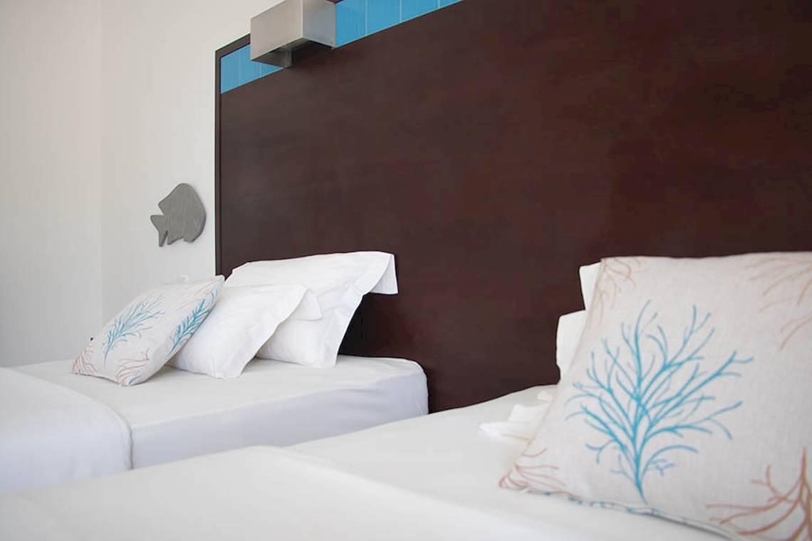 Doppelbett-Zimmer im Hotel Dunas De Sal mit blauen Dekor und Fisch-Wandkunst.