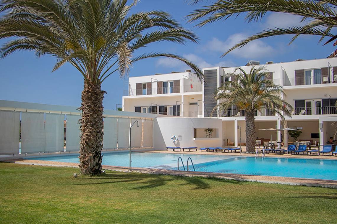 Außenbereich des Dunas De Sal Hotels mit Swimmingpool und Sonnenliegen.