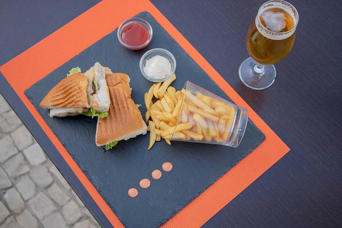 Sandwich, Pommes Frittes und Getränk auf einem Tisch serviert
