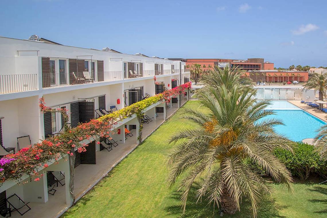 Außenbereich des Dunas De Sal Hotels mit Swimmingpool und Palme
