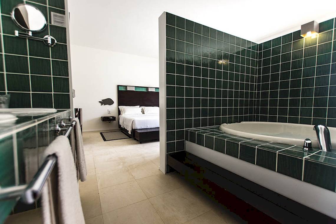 Ein Hotelzimmer mit einer Badewanne und einem Bett.