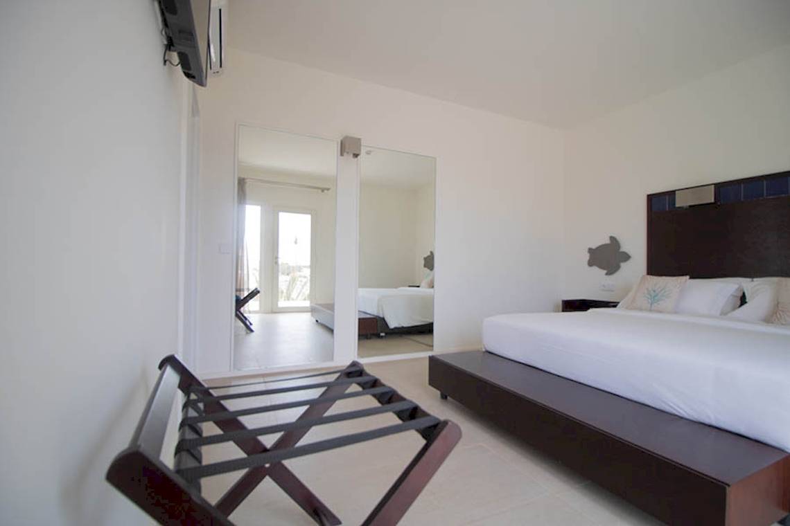 Ein modernes Hotelzimmer von Dunas De Sal mit weißem Bett und Spiegeln.