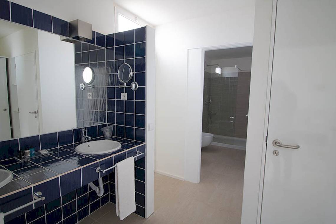 Badezimmer im Dunas De Sal Hotel mit blauen Fliesen und offenem Badezimmer