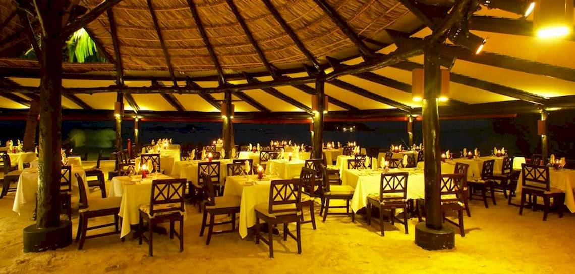Restaurantbereich im Paradise Sun Hotel mit abendlicher Beleuchtung und gedeckten Tischen.