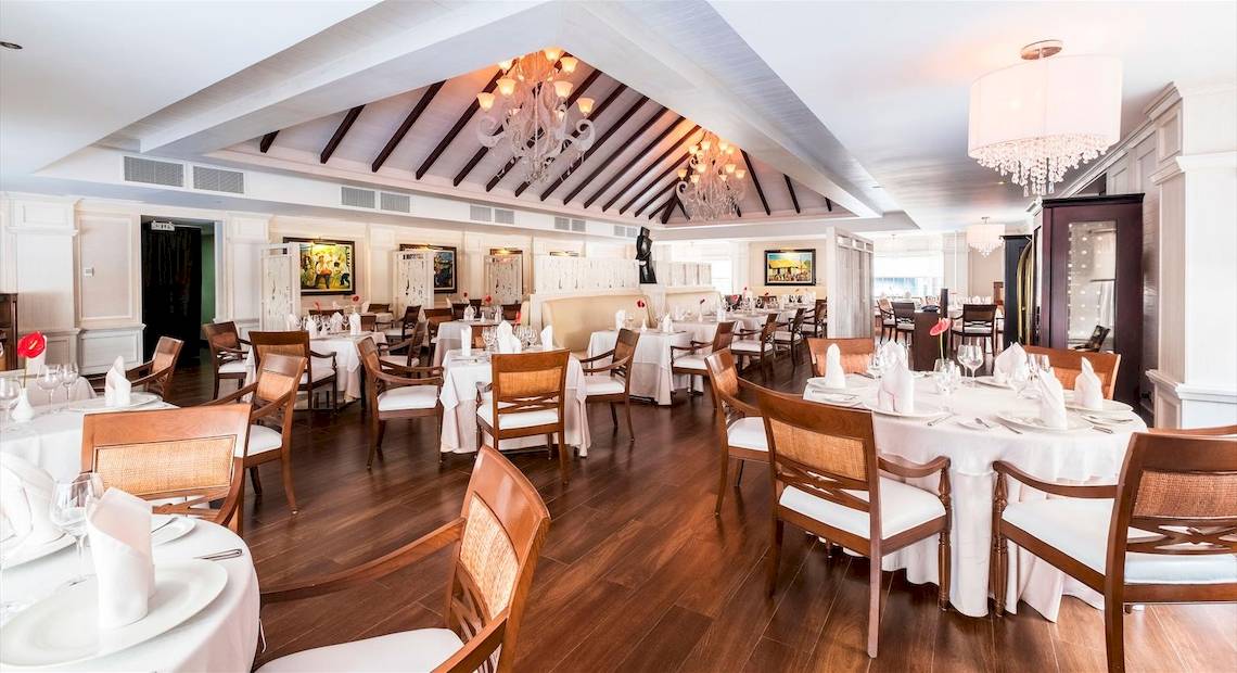 Innenansicht des Restaurants im Barcelo Bavaro Beach Hotel mit gedeckten Tischen und Stühlen.