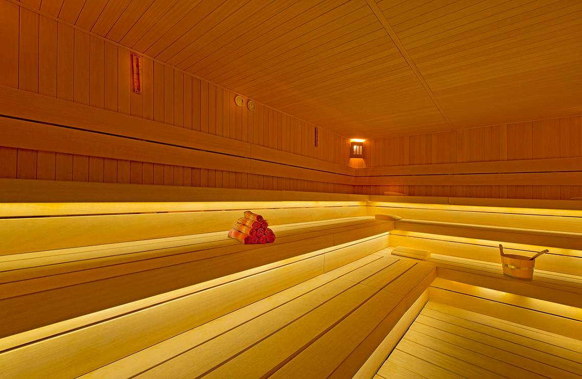 Sauna im Titanic Deluxe Lara Hotel mit Holzbänken und Beleuchtung.