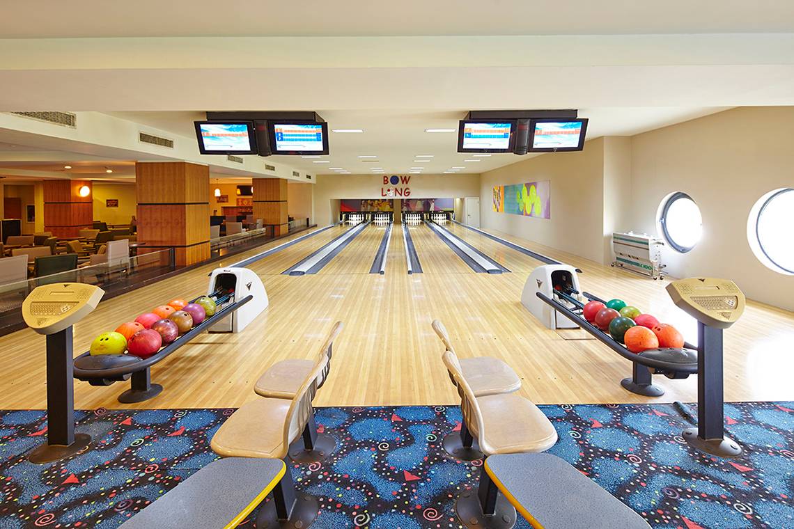 Bowlinghalle im Titanic Deluxe Lara Hotel mit Bowlingbahnen, Bowlingkugeln und Monitoren.