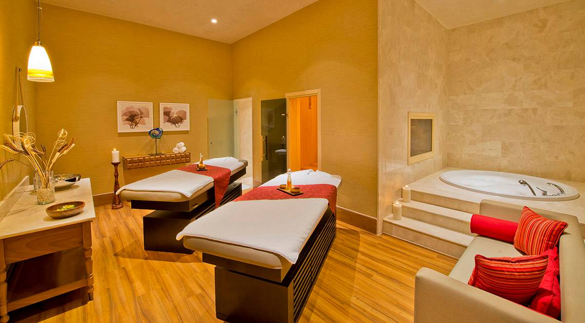 Spa-Behandlungsraum im Titanic Deluxe Lara Hotel mit zwei Massagetischen, einem Whirlpool und einem Sofa.