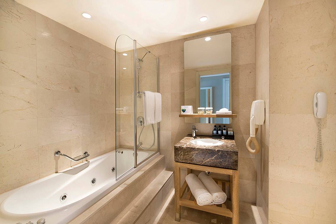 Hotel Titanic Deluxe Lara Badezimmer mit Badewanne, Dusche, Waschbecken und Föhn.