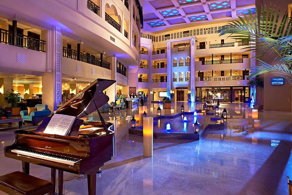 Ein elegantes Hotel-Lobby mit einem Klavier und blauer Beleuchtung.