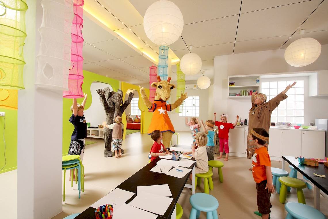 Kinder feiern im Hotel mit Animationsfiguren und haben Spaß.