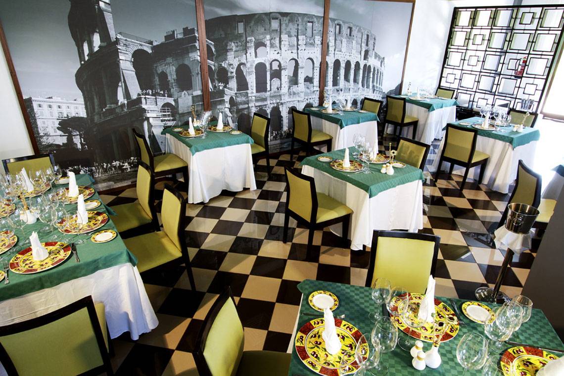 Innenansicht des Restaurants Valentin Varadero El Patriarca mit gedeckten Tischen und einem großen Wandbild des Kolosseums.