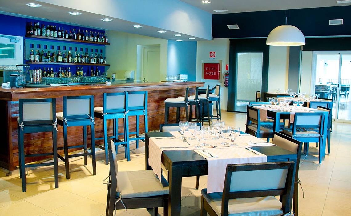 Barbereich im Valentin Varadero El Patriarca Hotel mit Theke, Stühlen und Tischen.