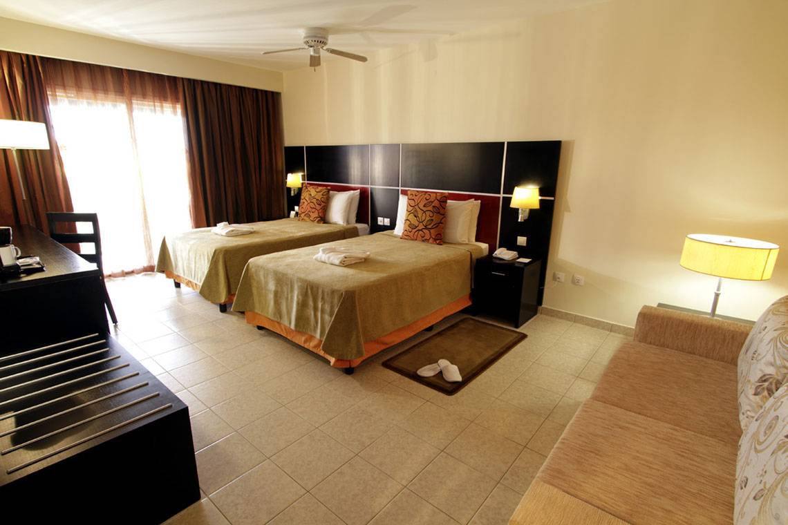 Doppelzimmer mit Sofa im Valentin Varadero El Patriarca Hotel, zwei Betten und ein Sofa.