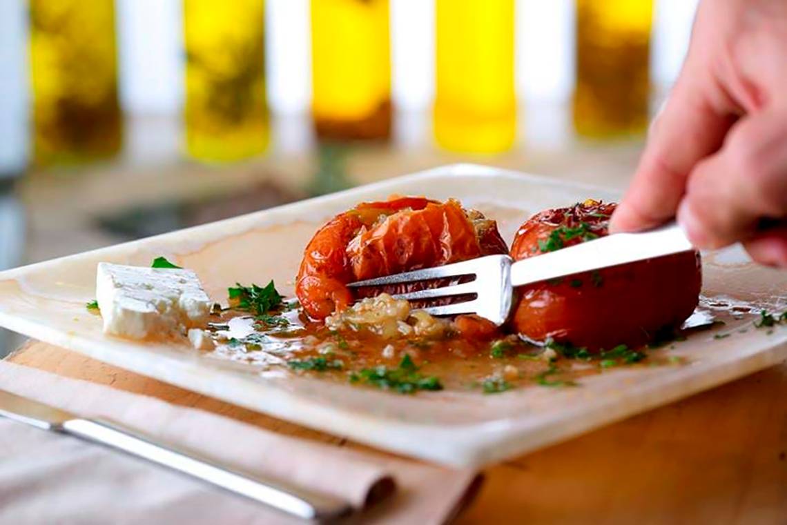 Gericht mit gebratenen Tomaten und Käse auf einem weißen Teller im Royal Blue Resort.