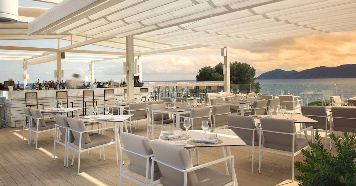 Außenterrasse des ME Ibiza Hotels mit Blick auf das Meer.