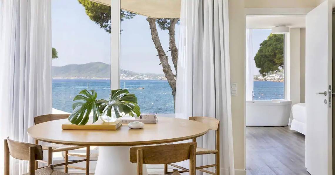 Innenraum des ME Ibiza Hotels mit Blick auf das Meer, Tisch und Pflanzen