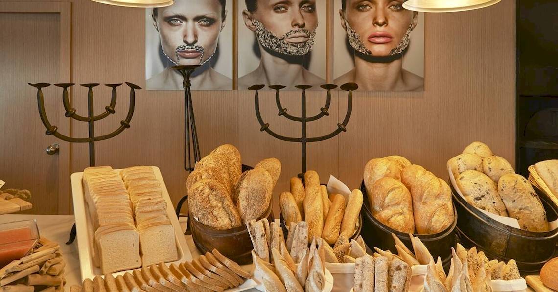Frühstücksbuffet im ME Ibiza Hotel mit verschiedenen Brotsorten und Dekoration im Hintergrund.