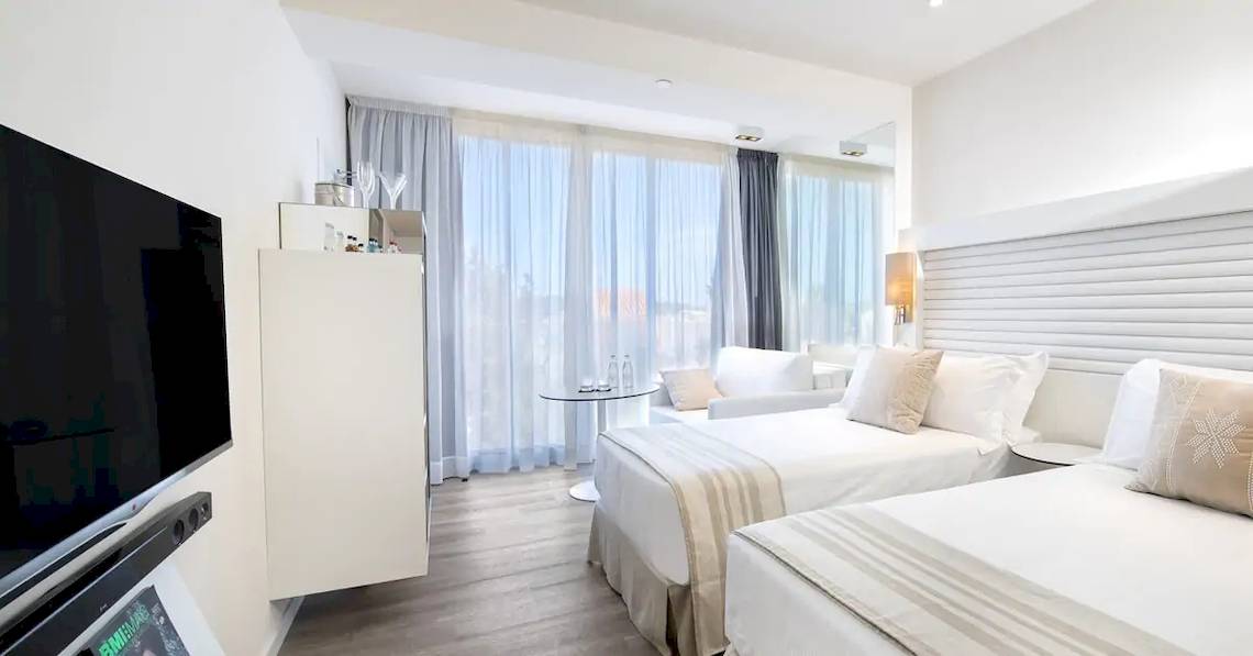 Doppelzimmer im ME Ibiza Hotel mit moderner Einrichtung und Aussicht auf die Stadt.