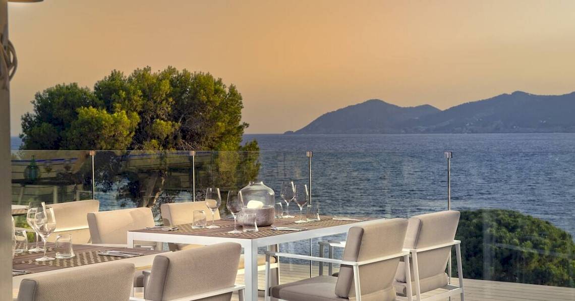 Terrasse des ME Ibiza Hotels mit Blick auf das Meer und die Berge