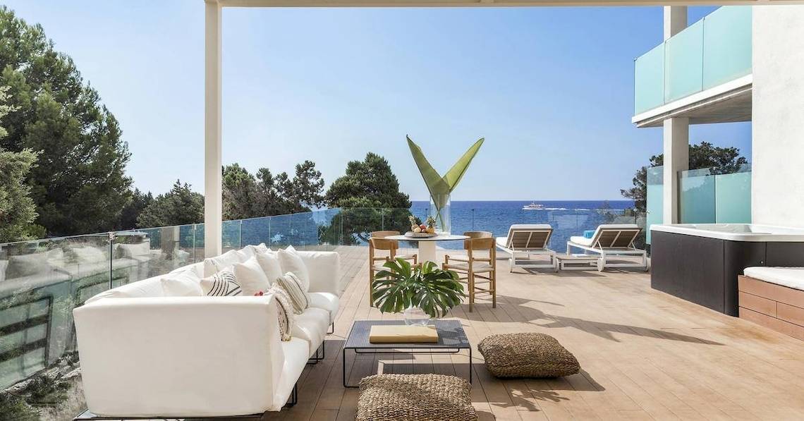 Terrasse des ME Ibiza Hotels mit Blick auf das Meer, Loungemöbel und Pflanzen