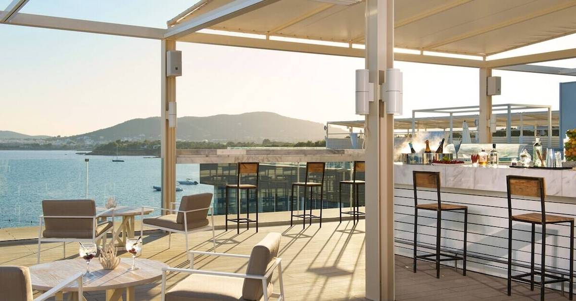 Dachterrasse des ME Ibiza Hotels mit Blick auf das Meer und die Berge.