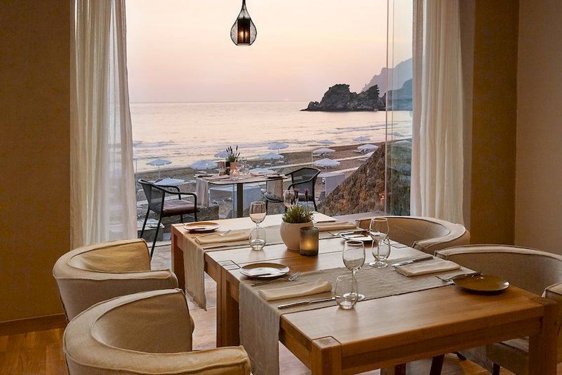 Innenansicht des Restaurants im Pelekas Kloster mit Blick auf das Meer und den Strand.