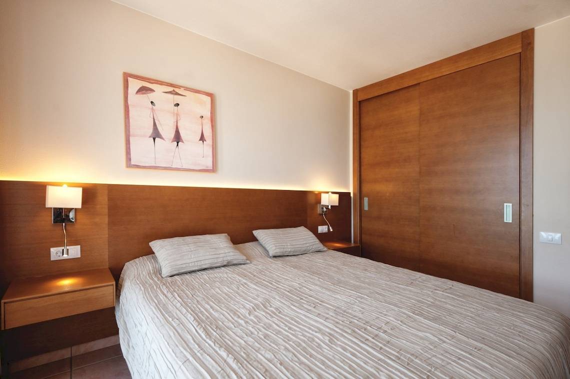 Schlafzimmer im Sotavento Beach Club Hotel mit zwei Betten, Nachttischen, Wandleuchten und einem Gemälde.
