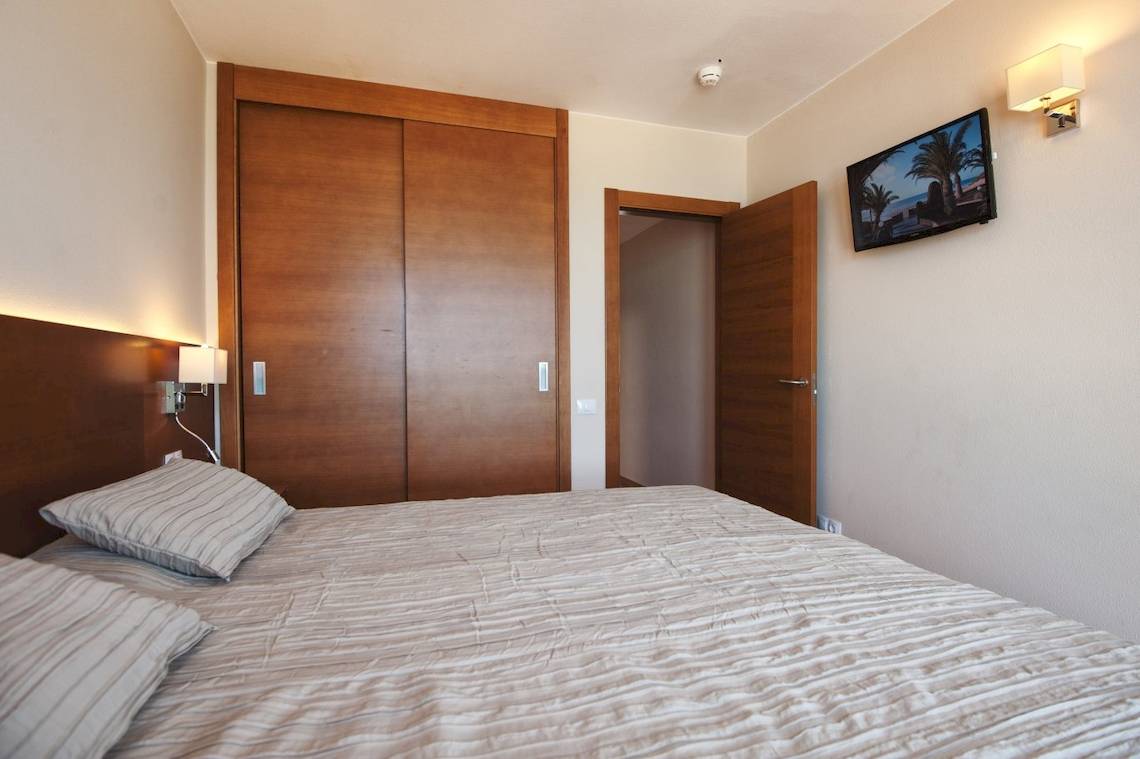 Bett mit zwei Kissen in einem geräumigen Zimmer des Sotavento Beach Clubs.