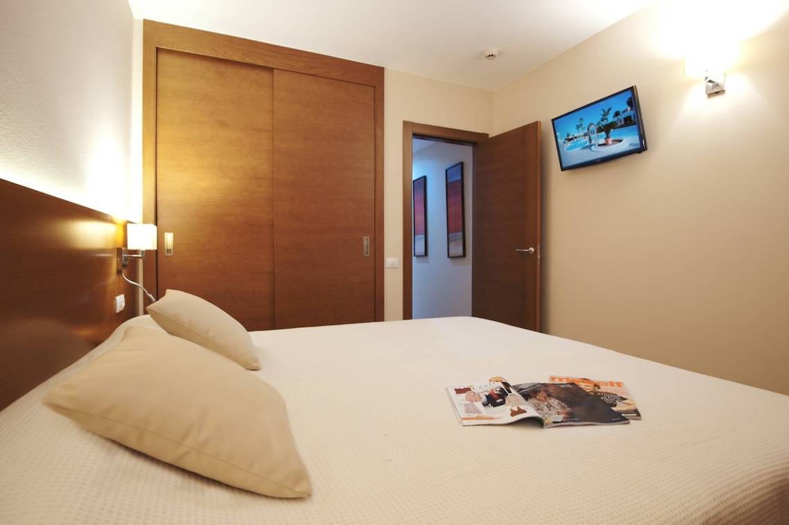 Hotelzimmer von Sotavento Beach Club mit Bett, Kissen, Zeitschriften und Fernseher